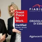 Due persone in abbigliamento professionale conversano in un ambiente d’ufficio; accanto, su sfondo blu, compaiono il logo Fiabilis Consulting Group, il badge Great Place to Work Certified e la scritta “Orgogliosi di esserlo #gptwcertified”.