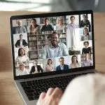 Schermo di un computer portatile che mostra una videoconferenza con più partecipanti disposti in riquadri, a rappresentare un evento online dedicato a strategie e strumenti per le risorse umane.