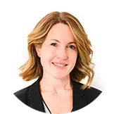 Un ritratto fotografico professionale di Fernanda Peterson, CEO e Area Executive Director di Fiabilis Italia, in posa sorridente e sicura, con un blazer scuro e uno sfondo neutro.