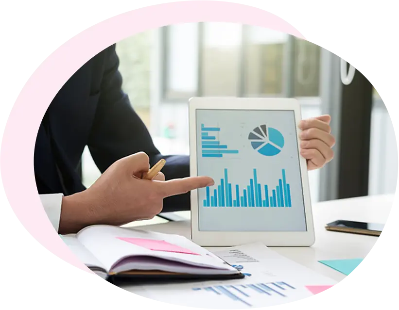 Mano con pennino che analizza report finanziari e grafici su una scrivania per la valutazione dei parametri aziendali.