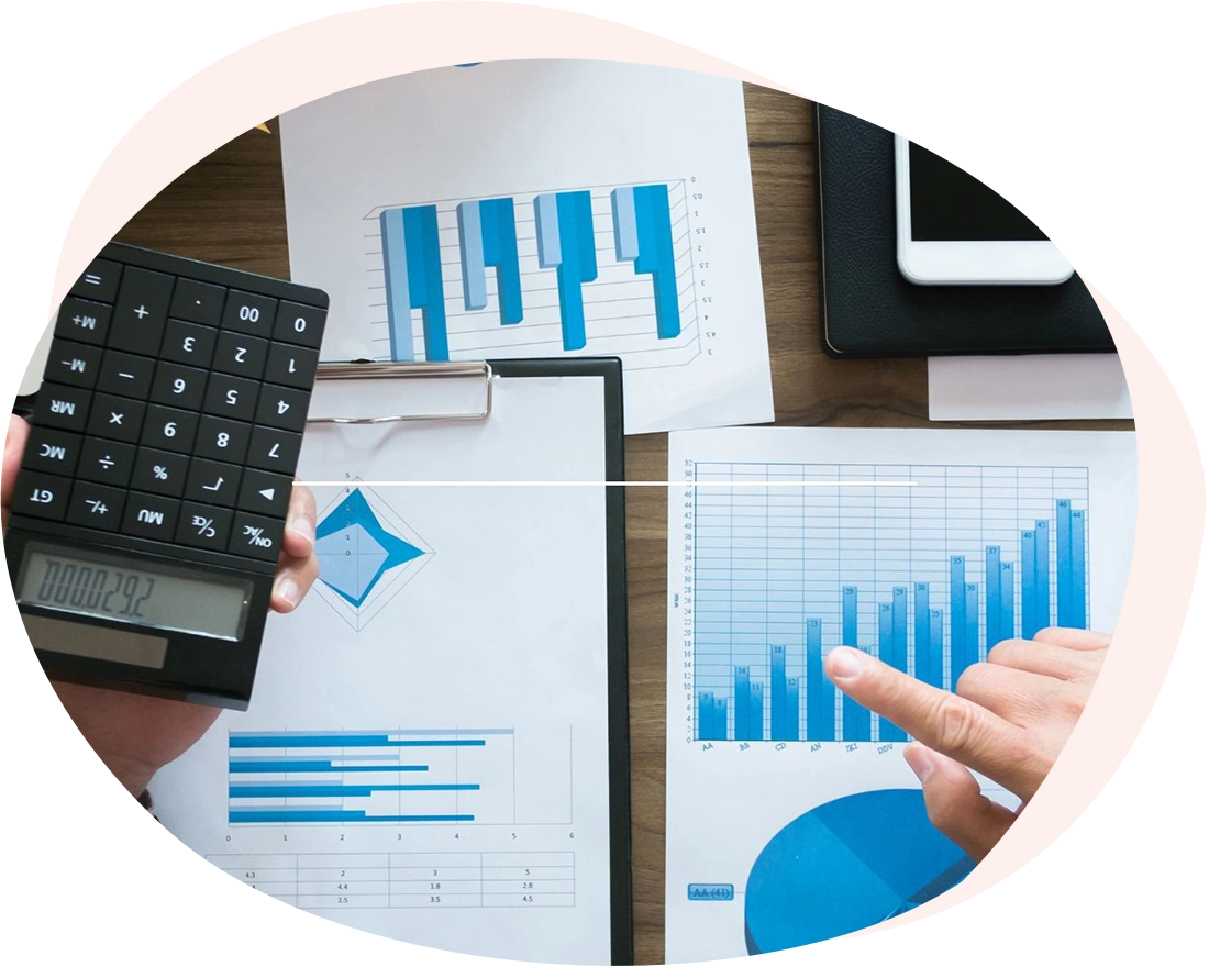 Vista dall'alto di una scrivania con mani che analizzano grafici finanziari e usano una calcolatrice, a rappresentare l'approccio data-driven di FundLink per la valutazione dei bandi.