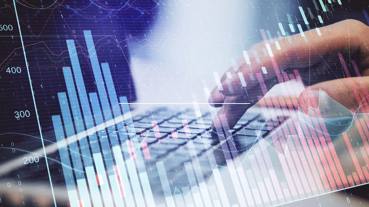 Mani che digitano al computer con grafici finanziari in crescita in sovrimpressione, a simboleggiare l'analisi dei dati per accedere alle opportunità di finanza agevolata con Fundlink.